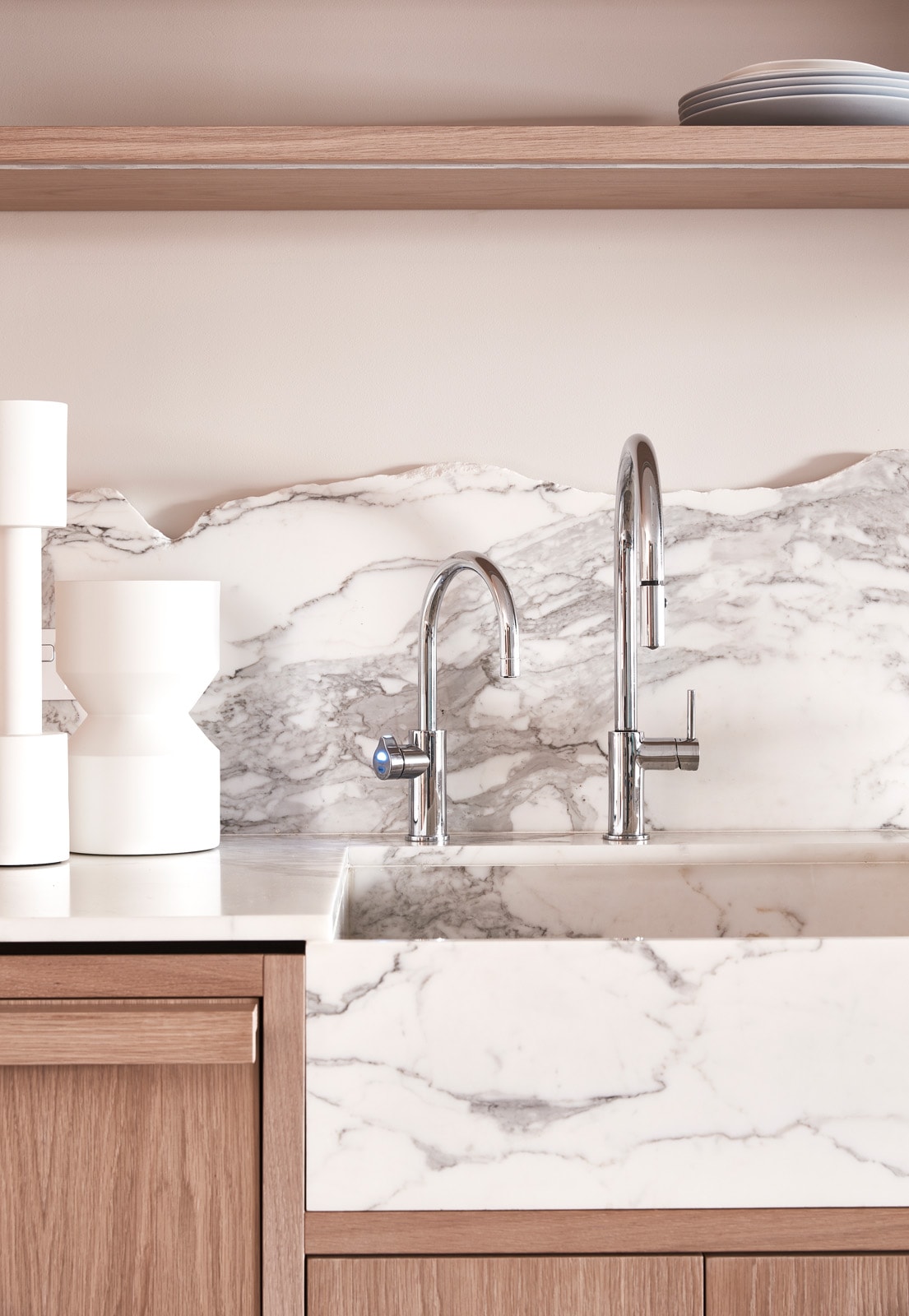 Timber vanity cabinetry beneath a marble benchtop and integrated stone sink.